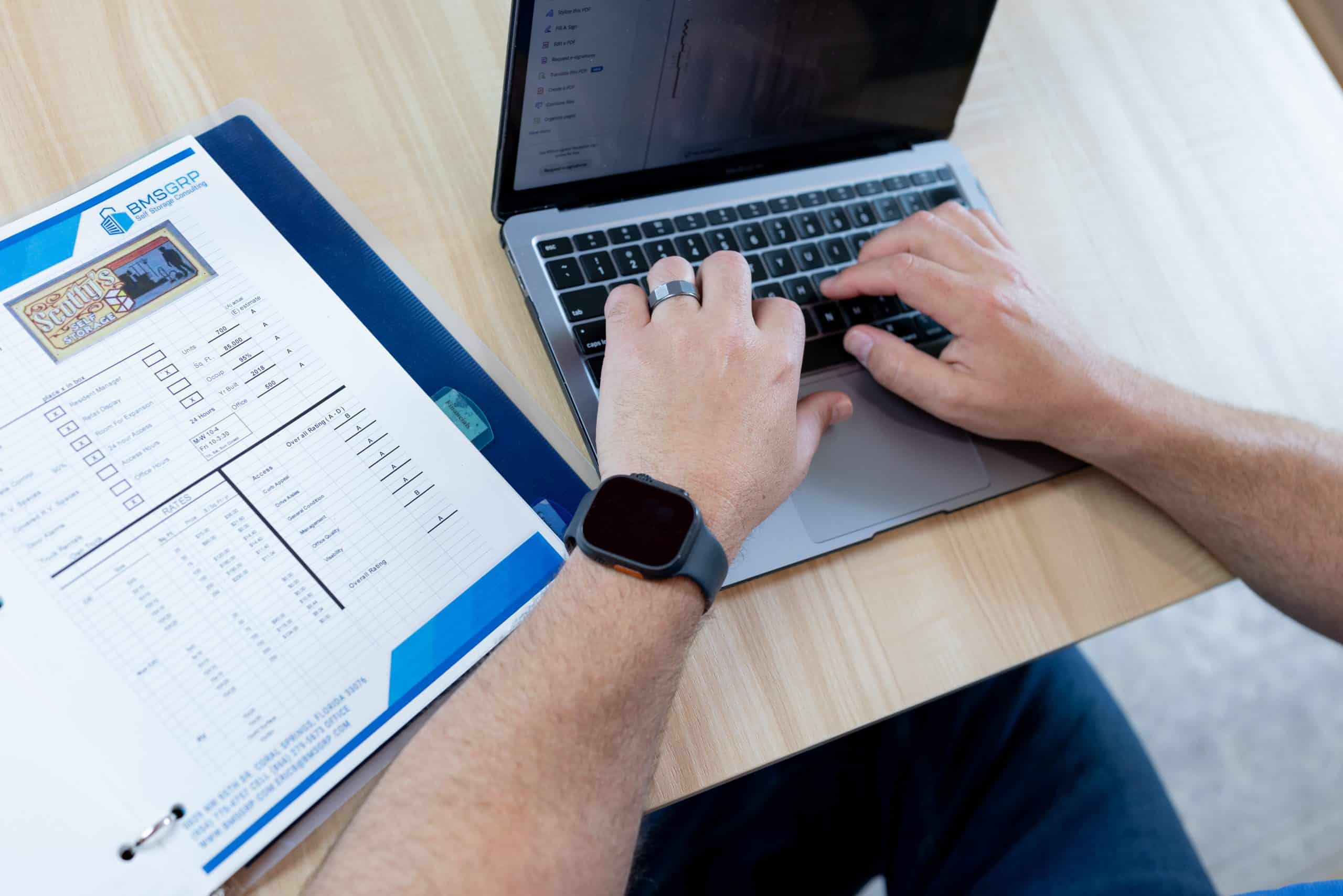 Self storage expert reviewing a feasibility report on a computer for a self storage project